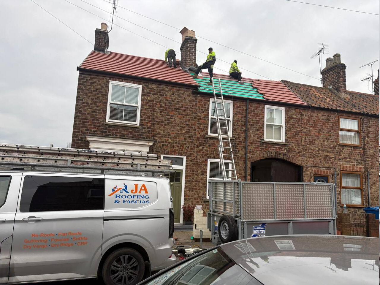 JA Roofing team re-tiling a terraced roof with new red clay tiles and breathable membrane